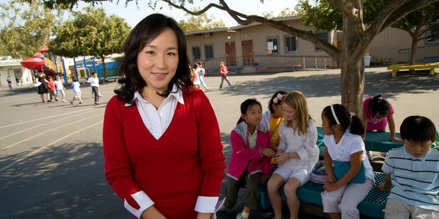 A woman works with young children at an elementary school - Ƶ